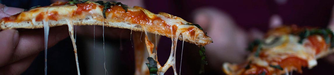 People making a mess with a pizza in a restaurant