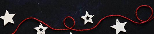 Red ribbon with white Christmas themed stars on a navy backdrop