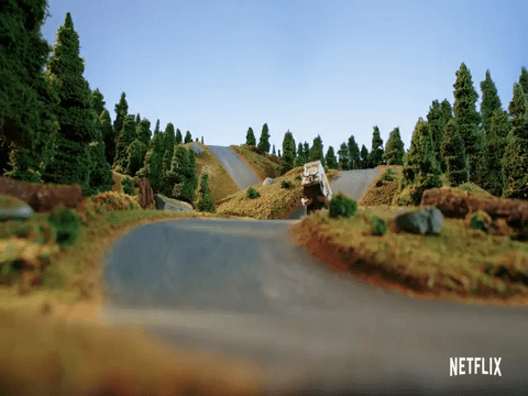 animation showing a food truck at speed fly over a winding road and come screeching to a halt in a cloud of smoke