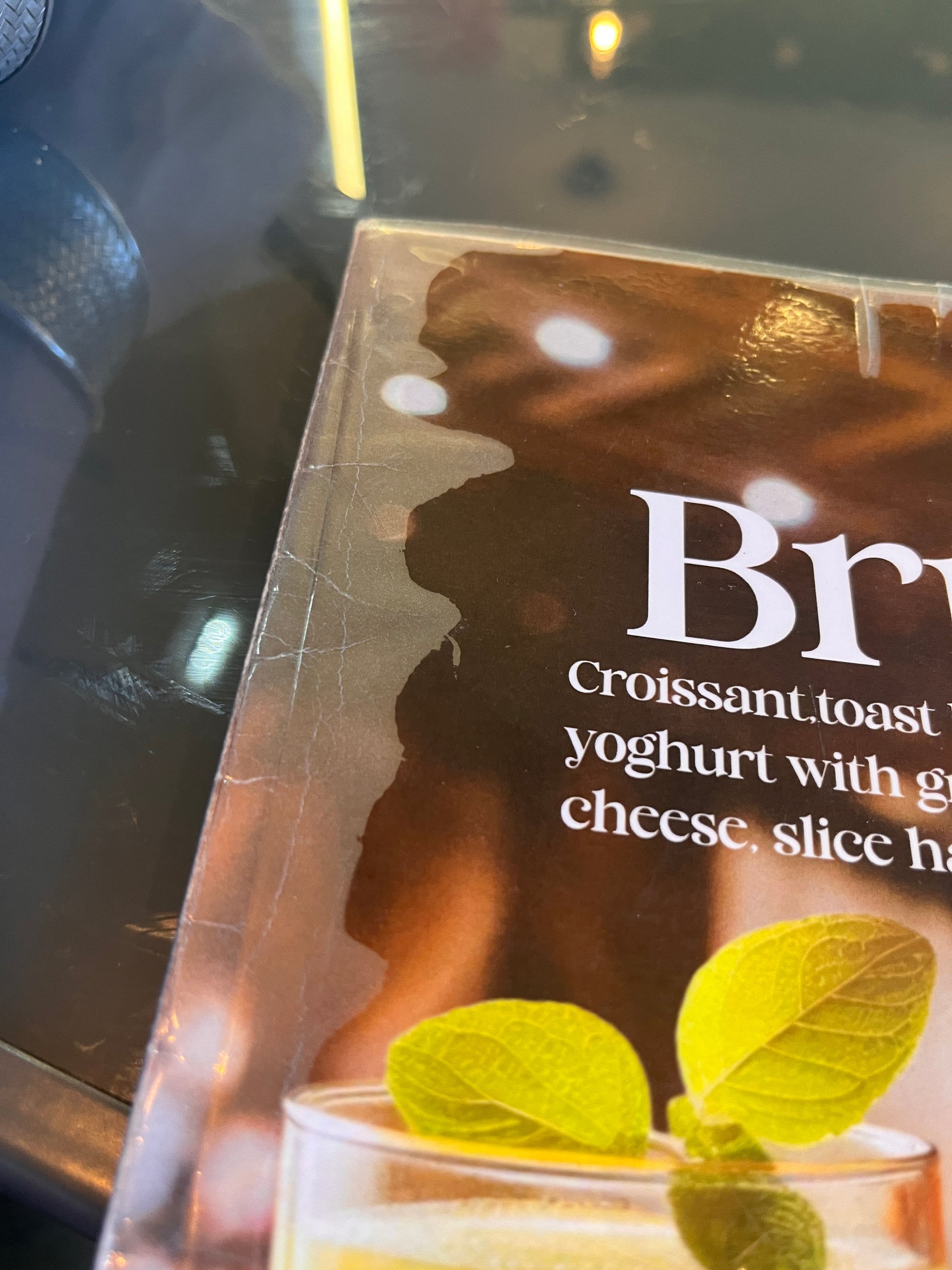An encapsulated menu showing the clear laminate separating from the printed card underneath, with visible delamination along the edge.