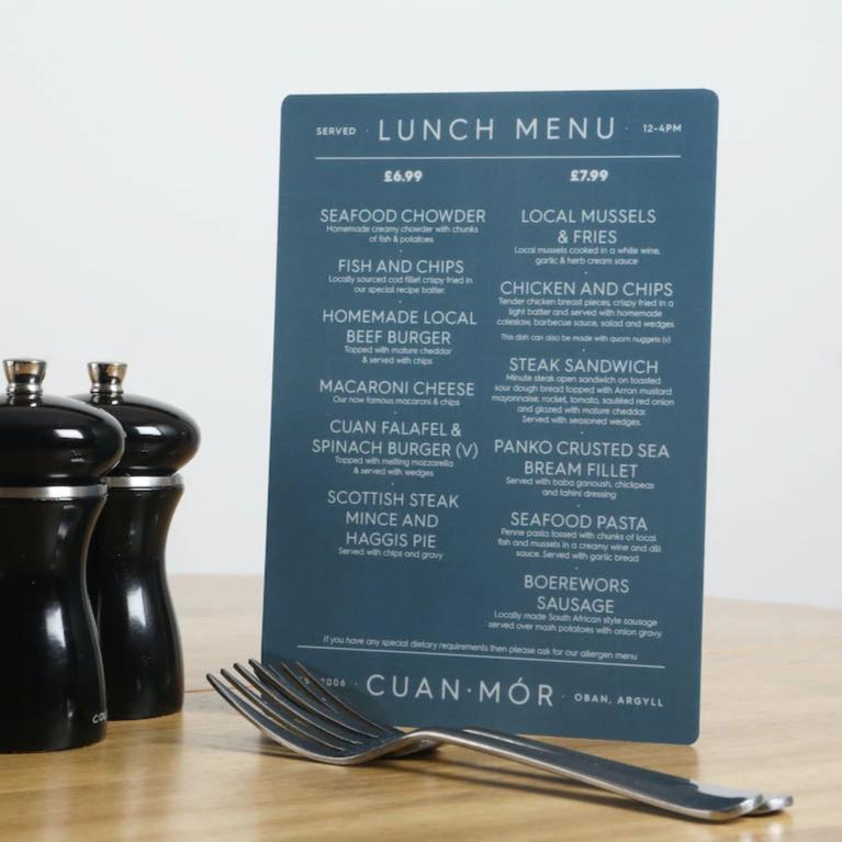 A5 portrait blue lunch menu on a table beside pepper grinder and cutlery to show scale