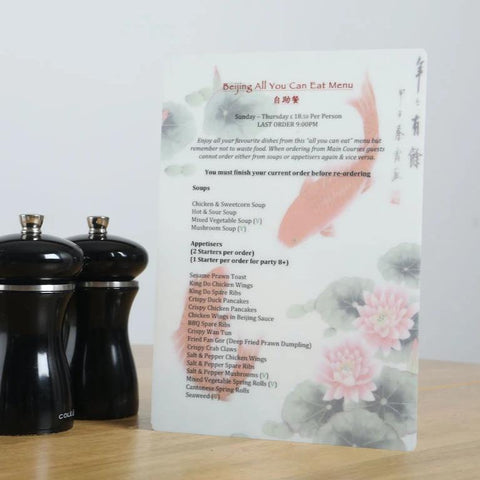 A5 Oriental Buffet menu on a table beside pepper grinders to show scale