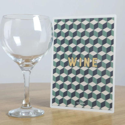 A5 portrait wine list on a table beside a large wine glass to show scale